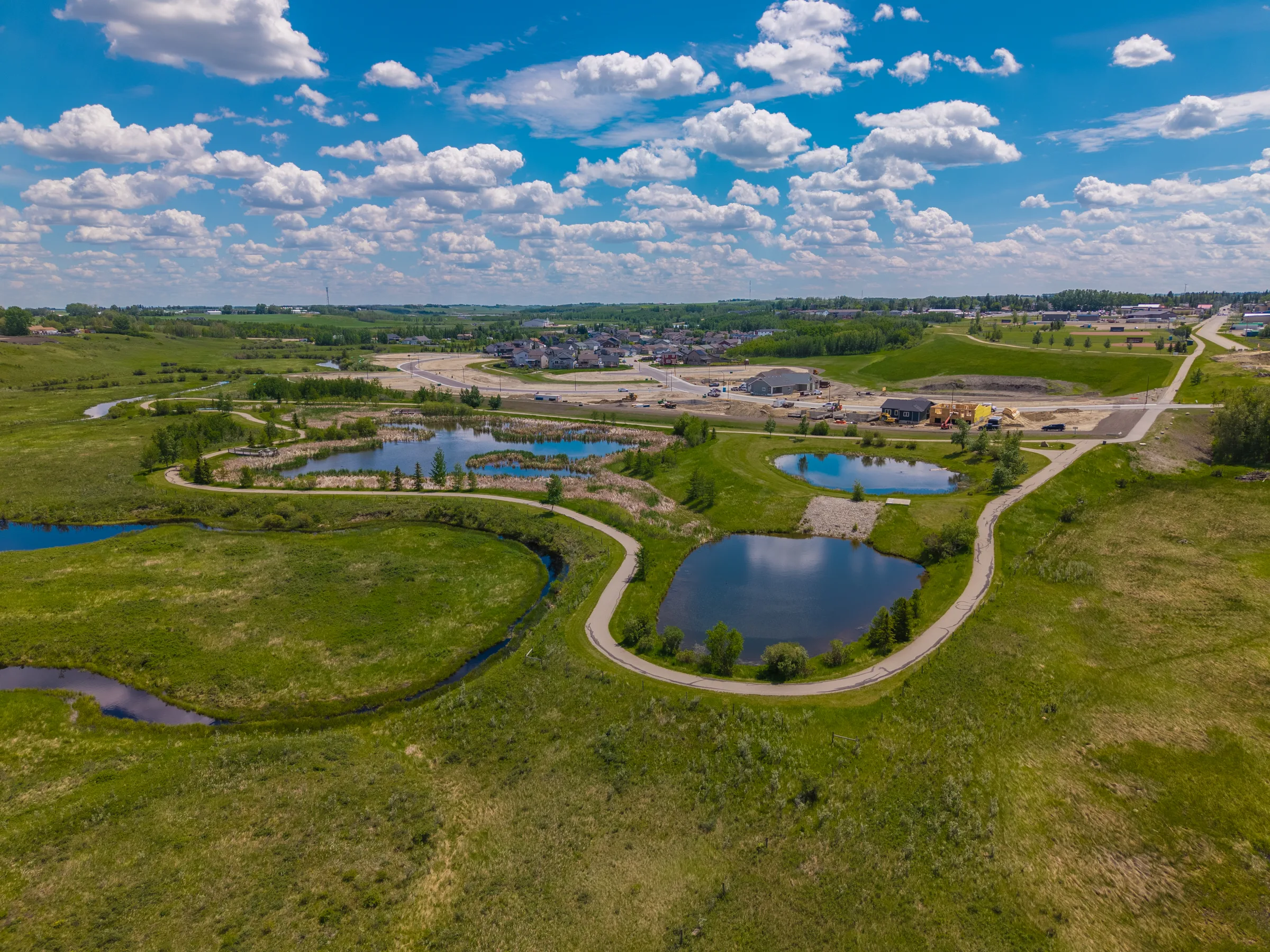 Aerial view of Valarosa's ponds, walking paths and protected greenspace in Didsbury, Alberta